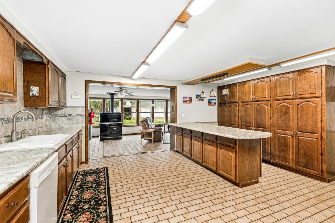 3723 Birchwood Road Kettle River, MN 55757 - Photo 6 of 48 Kitchen featuring brown cabinetry, dishwasher, ceiling fan, and a peninsula