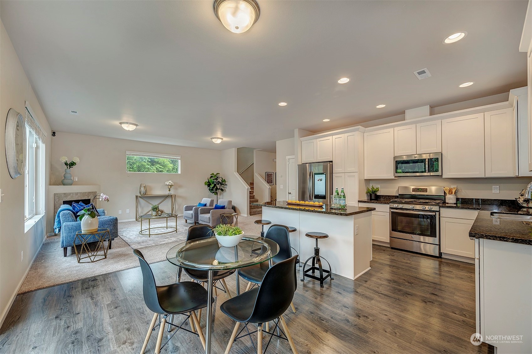 12329 23rd Drive Southeast, Unit 10 Everett, WA 98208 - Photo 7 of 24 a living room with stainless steel appliances kitchen island granite countertop furniture wooden floor and a view of kitchen