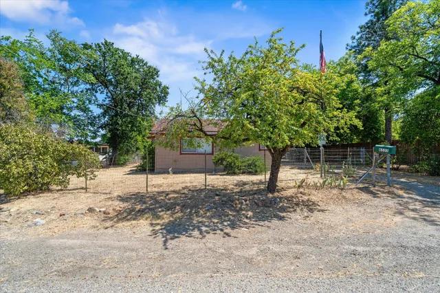 an aerial view of house with yard and mountain view in back
