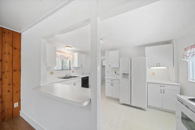 a large white kitchen with cabinets