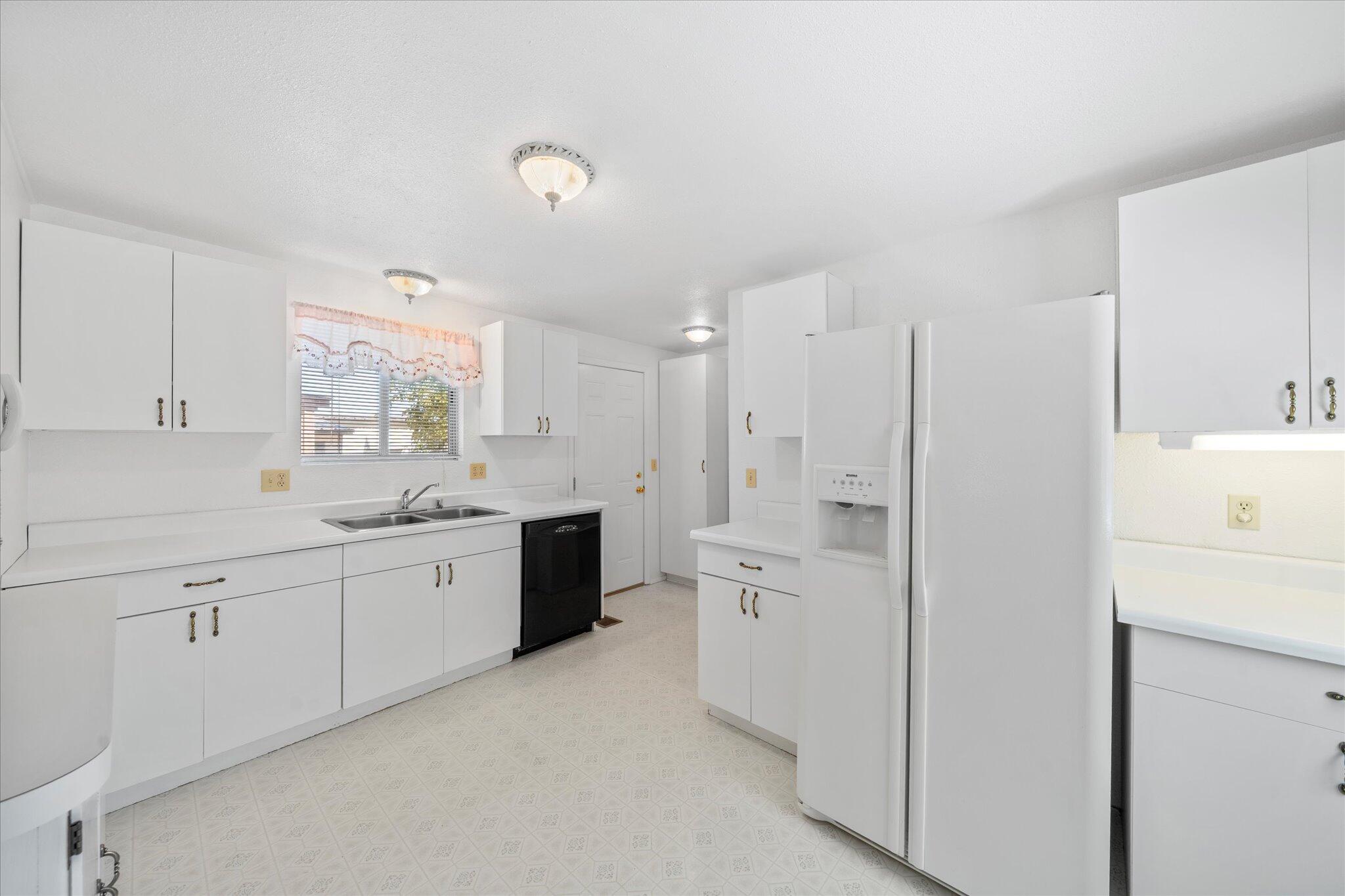 6535 Placer Road Igo, CA 96047 - Photo 6 of 39 a large white kitchen with cabinets a sink a window and a refrigerator