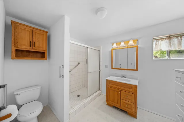 a spacious bathroom with a shower toilet sink and mirror