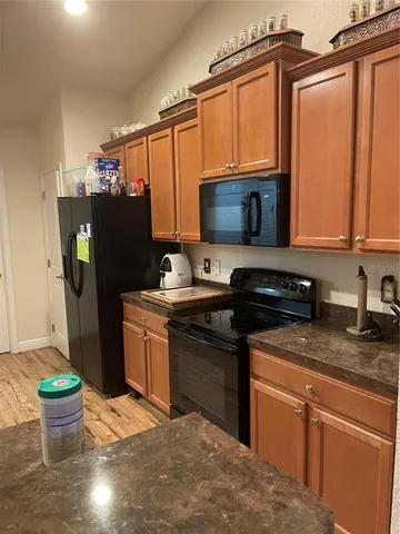 a kitchen with stainless steel appliances granite countertop a refrigerator and a stove top oven