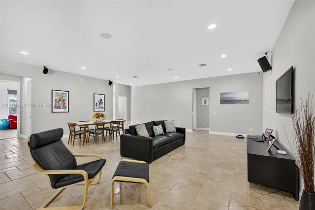 a kitchen with stainless steel appliances granite countertop a stove a sink a dining table and chairs