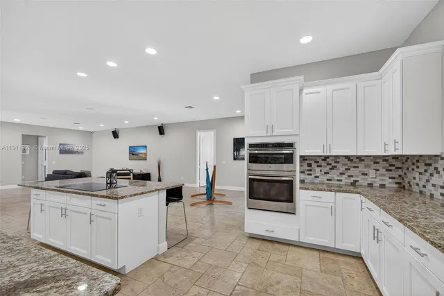 a kitchen with stainless steel appliances granite countertop a refrigerator sink and stove