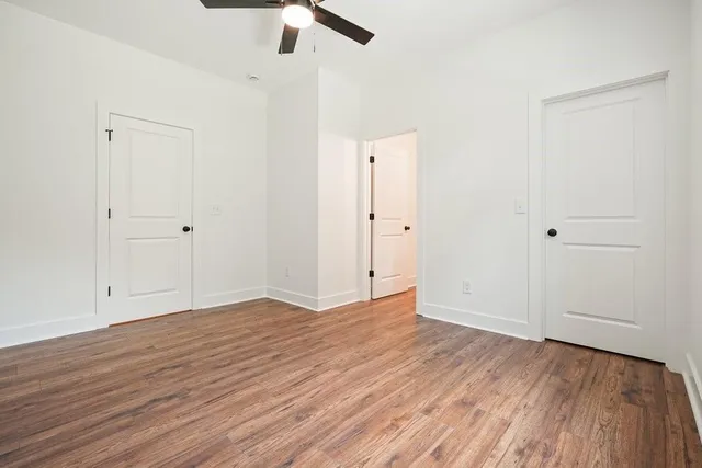 a view of a room with wooden floor and ceiling fan