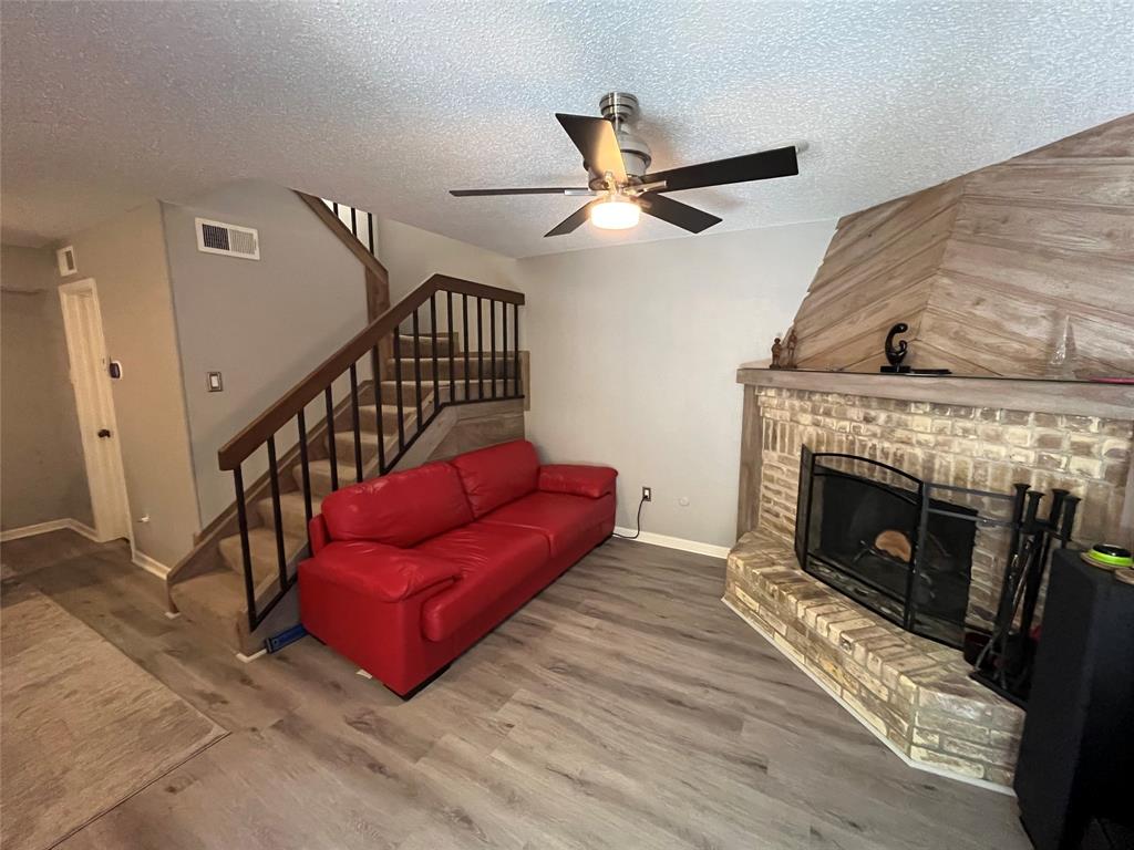 a living room with furniture a fireplace and a ceiling fan