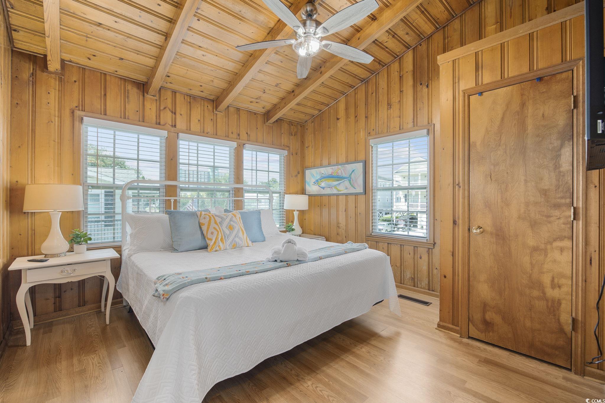 222 Calhoun Drive Murrells Inlet, SC 29576 - Photo 14 of 40 Bedroom featuring ceiling fan, lofted ceiling with beams, multiple windows, and wooden walls