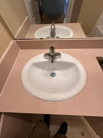 a bathroom with a sink a toilet and a mirror