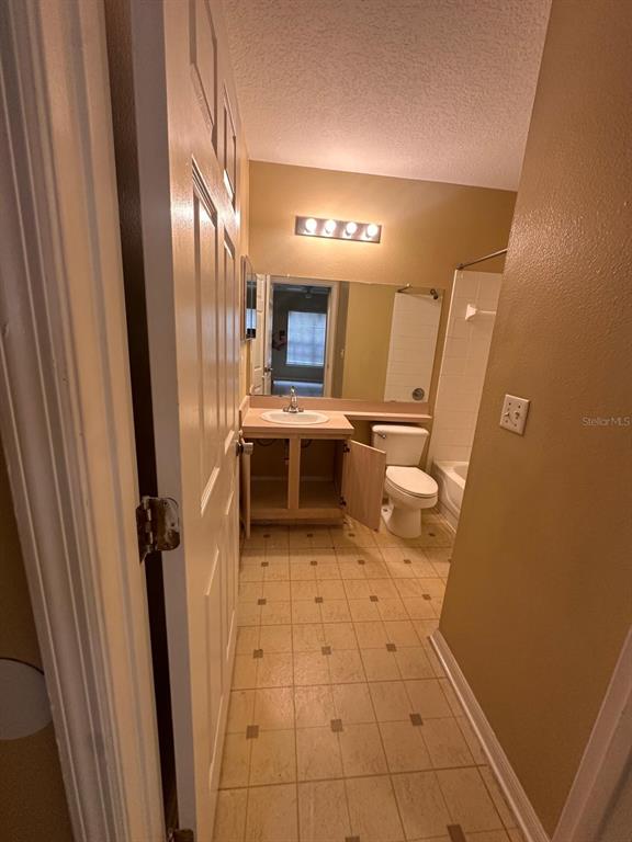4364 South Kirkman Road, Unit 313 Orlando, FL 32811 - Photo 18 of 27 a bathroom with a sink a toilet and a mirror