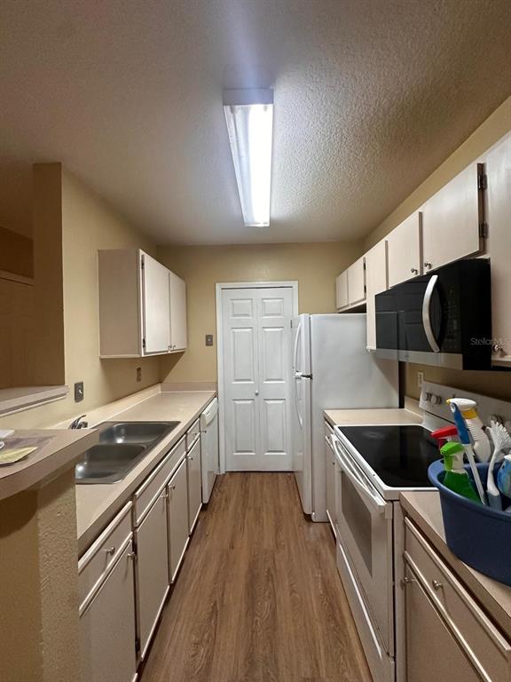 4364 South Kirkman Road, Unit 313 Orlando, FL 32811 - Photo 4 of 27 a kitchen with stainless steel appliances granite countertop a sink and a stove