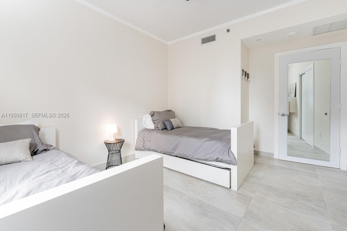 1060 Brickell Avenue, Unit 1507 Miami, FL 33131 - Photo 13 of 56 a bedroom with a bed and a cabinets