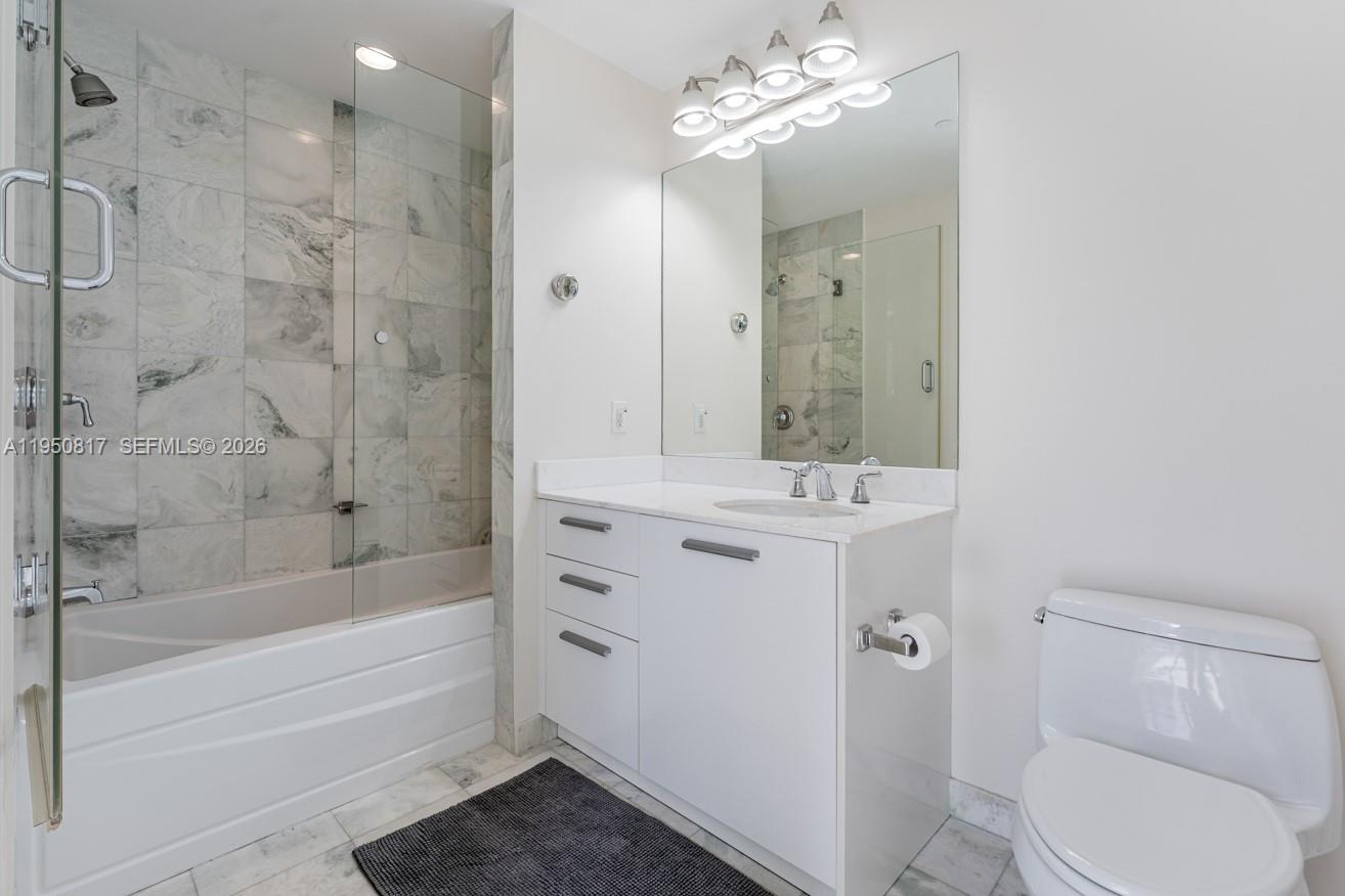 1060 Brickell Avenue, Unit 1507 Miami, FL 33131 - Photo 16 of 56 a bathroom with a bathtub shower sink mirror and toilet