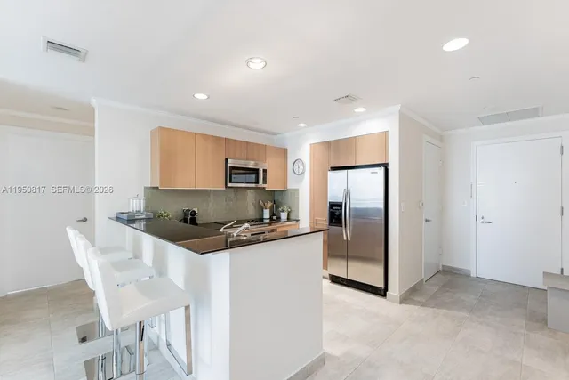 a kitchen with stainless steel appliances granite countertop a refrigerator and a stove top oven