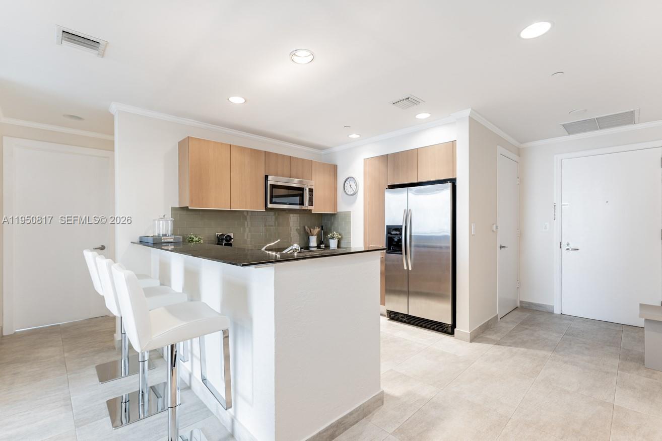 1060 Brickell Avenue, Unit 1507 Miami, FL 33131 - Photo 30 of 56 a kitchen with kitchen island cabinets and refrigerator