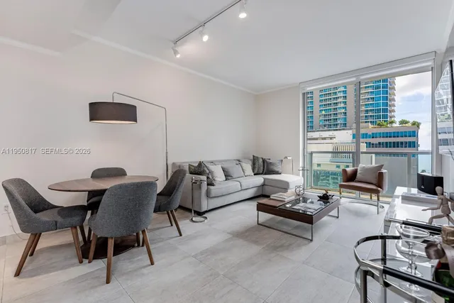 a living room with furniture and a floor to ceiling window