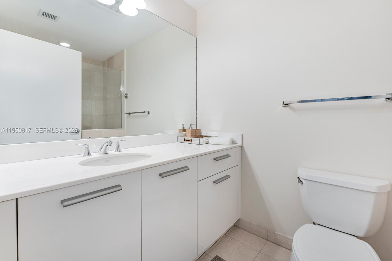 1060 Brickell Avenue, Unit 1507 Miami, FL 33131 - Photo 10 of 56 a bathroom with a toilet sink and mirror