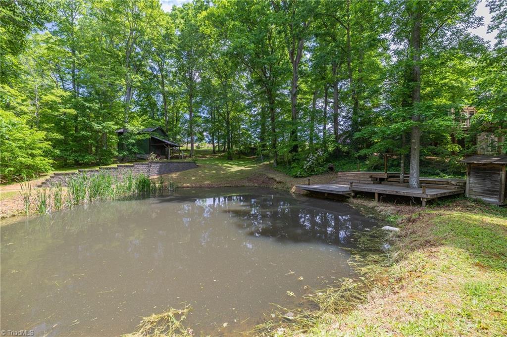 1134 Edwards Farm Road King, NC 27021 - Photo 36 of 50 Creek fed sitting pond with lounging deck stocked with blue gill and hybrid black crappie fishies.