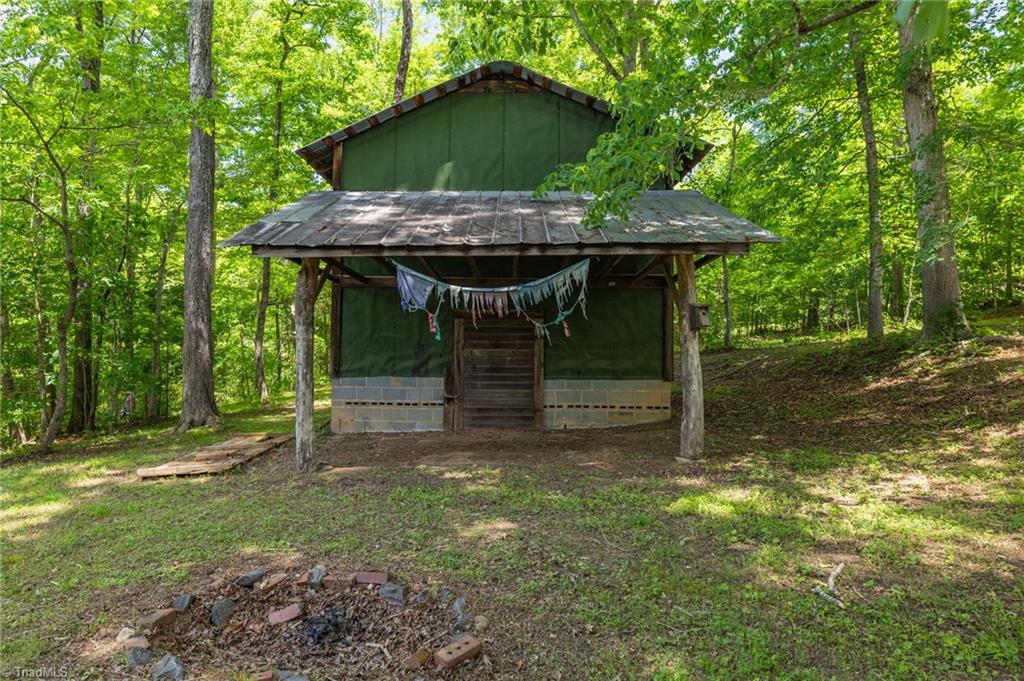 1134 Edwards Farm Road King, NC 27021 - Photo 37 of 50 Just across the pond sits this well maintained tobacco barn, a ton of additional storage, complete with prayer flags and a firepit for sitting awhile to honor a simpler time. Hmmm...maybe AIRBNB Potential???