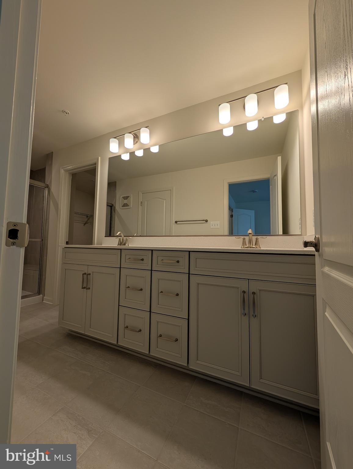 9985 A Justify Run Laurel, MD 20723 - Photo 17 of 33 a spacious bathroom with a double vanity sink and a mirror