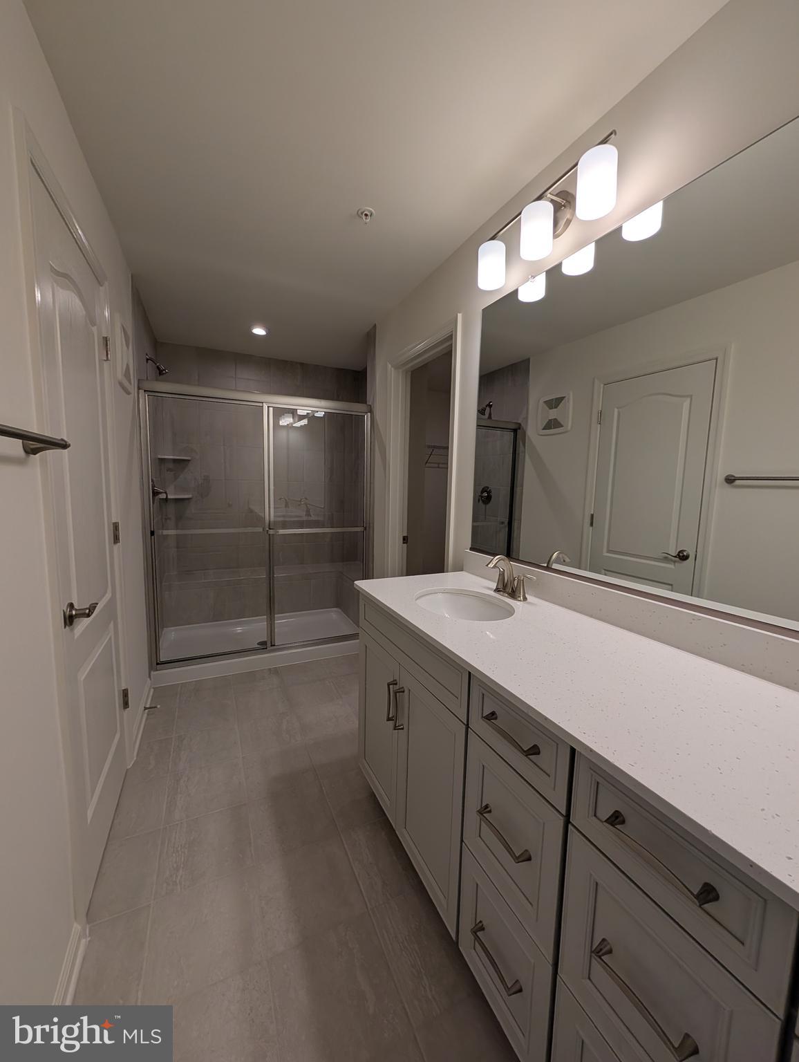 9985 A Justify Run Laurel, MD 20723 - Photo 18 of 33 a bathroom with a double vanity sink and a mirror