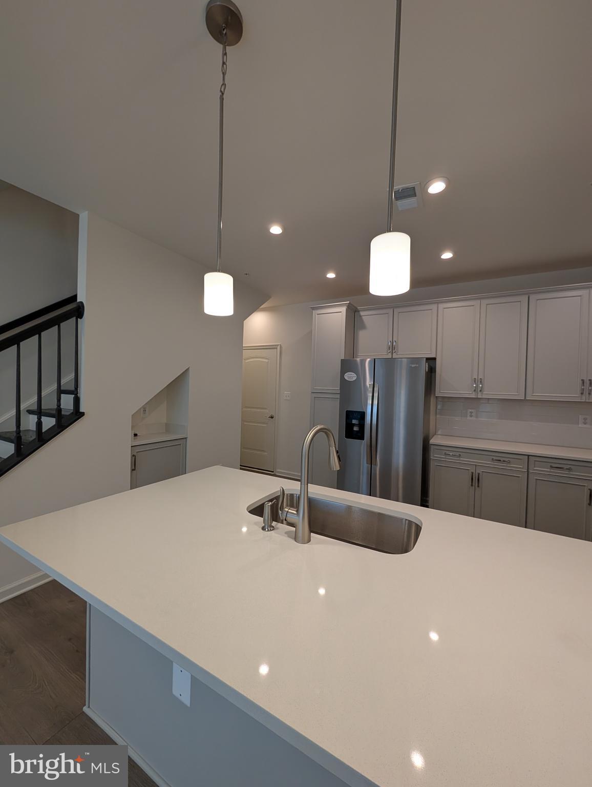 9985 A Justify Run Laurel, MD 20723 - Photo 5 of 33 a large kitchen with kitchen island a sink stainless steel appliances and a chandelier