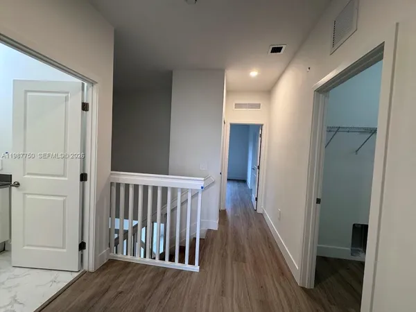 a view of hallway with wooden floor