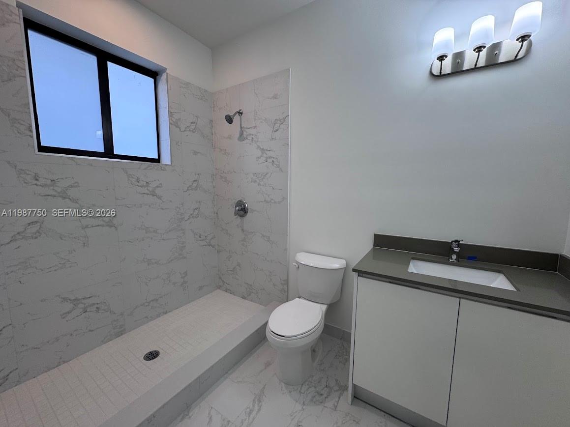 34435 Southwest 189th Court Homestead, FL 33030 - Photo 14 of 28 a bathroom with a granite countertop sink a toilet and shower