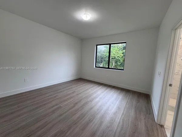 a view of empty room with wooden floor