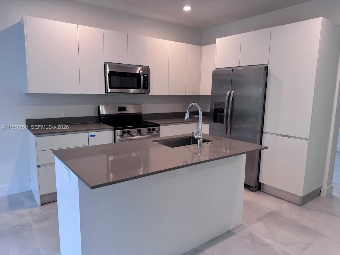 34435 Southwest 189th Court Homestead, FL 33030 - Photo 2 of 28 a kitchen with stainless steel appliances granite countertop a sink a microwave a refrigerator and a stove