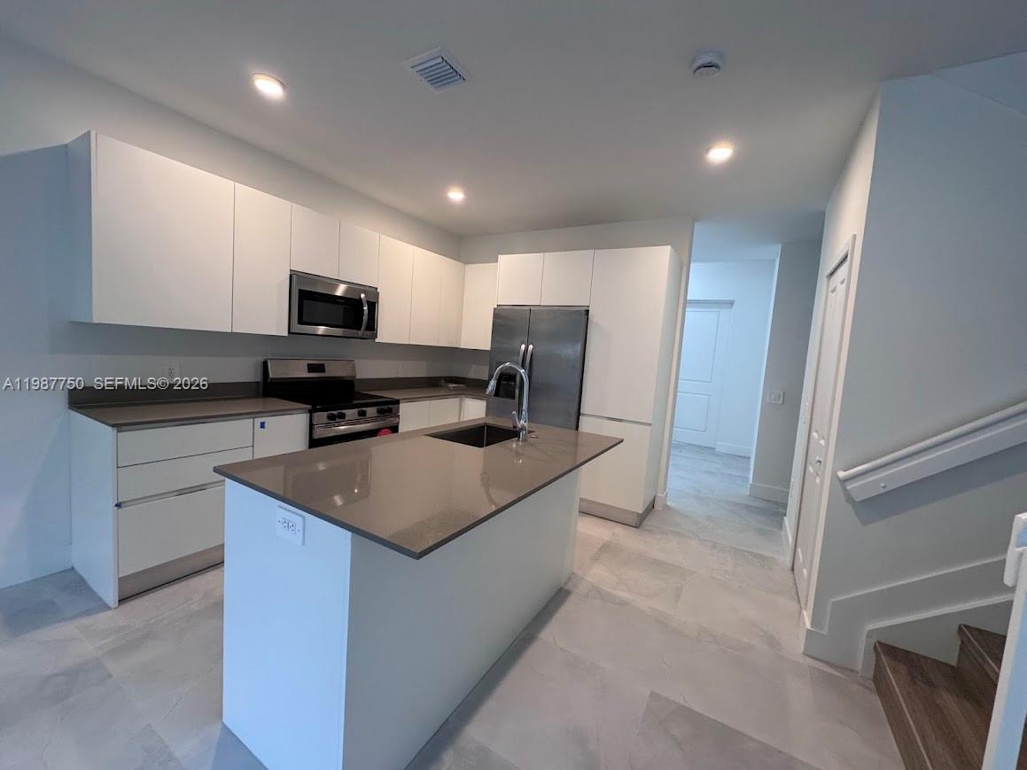 34435 Southwest 189th Court Homestead, FL 33030 - Photo 22 of 28 a kitchen with stainless steel appliances granite countertop a sink stove and refrigerator