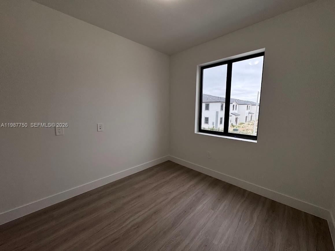 34435 Southwest 189th Court Homestead, FL 33030 - Photo 9 of 28 a view of an empty room with wooden floor and a window