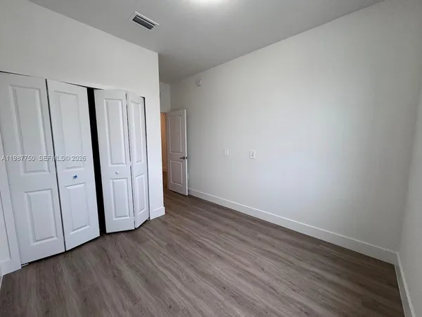 a view of an empty room with wooden floor