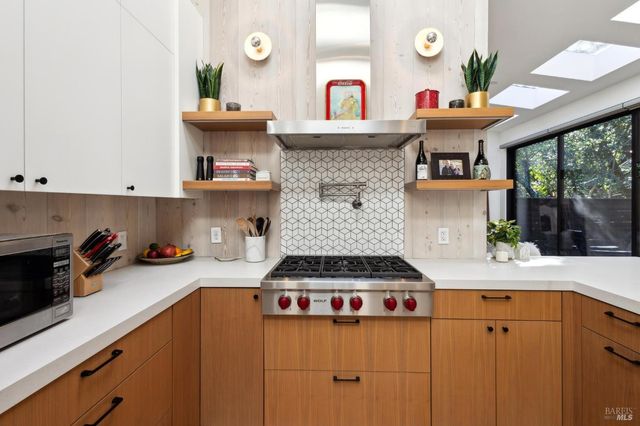 a kitchen with stainless steel appliances a sink and a large window