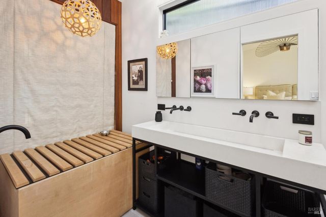 a bathroom with a sink mirror and a shower