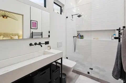 a view of a room that has a bed and wooden floor