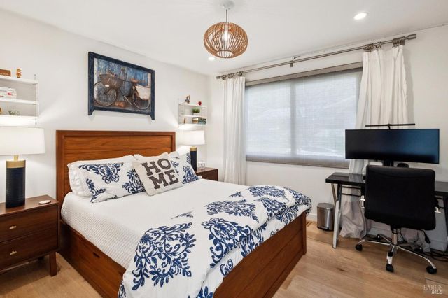 a bedroom with a bed and a lamp on dresser