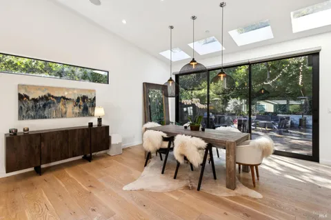 a dining room with wooden floor glass table and chairs