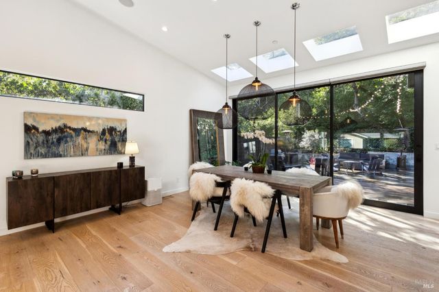 a dining room with wooden floor glass table and chairs