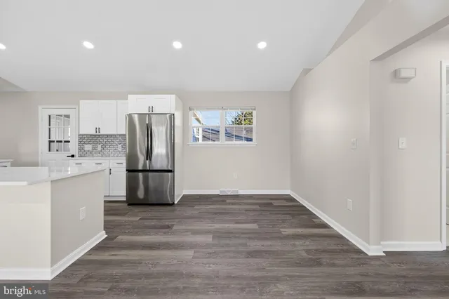 a living room with lots of furniture and kitchen view