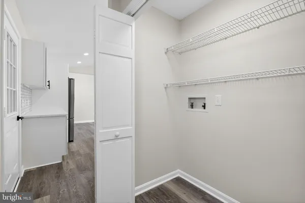 a view of a room with wooden floor and a ceiling fan
