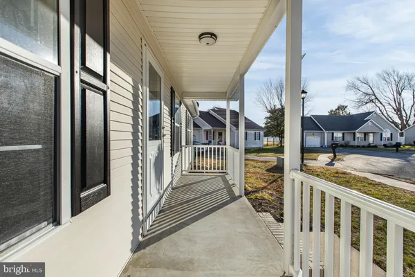 a living room with furniture and kitchen view with wooden floor