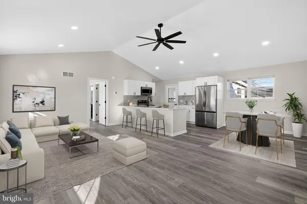 a living room with lots of furniture and kitchen view
