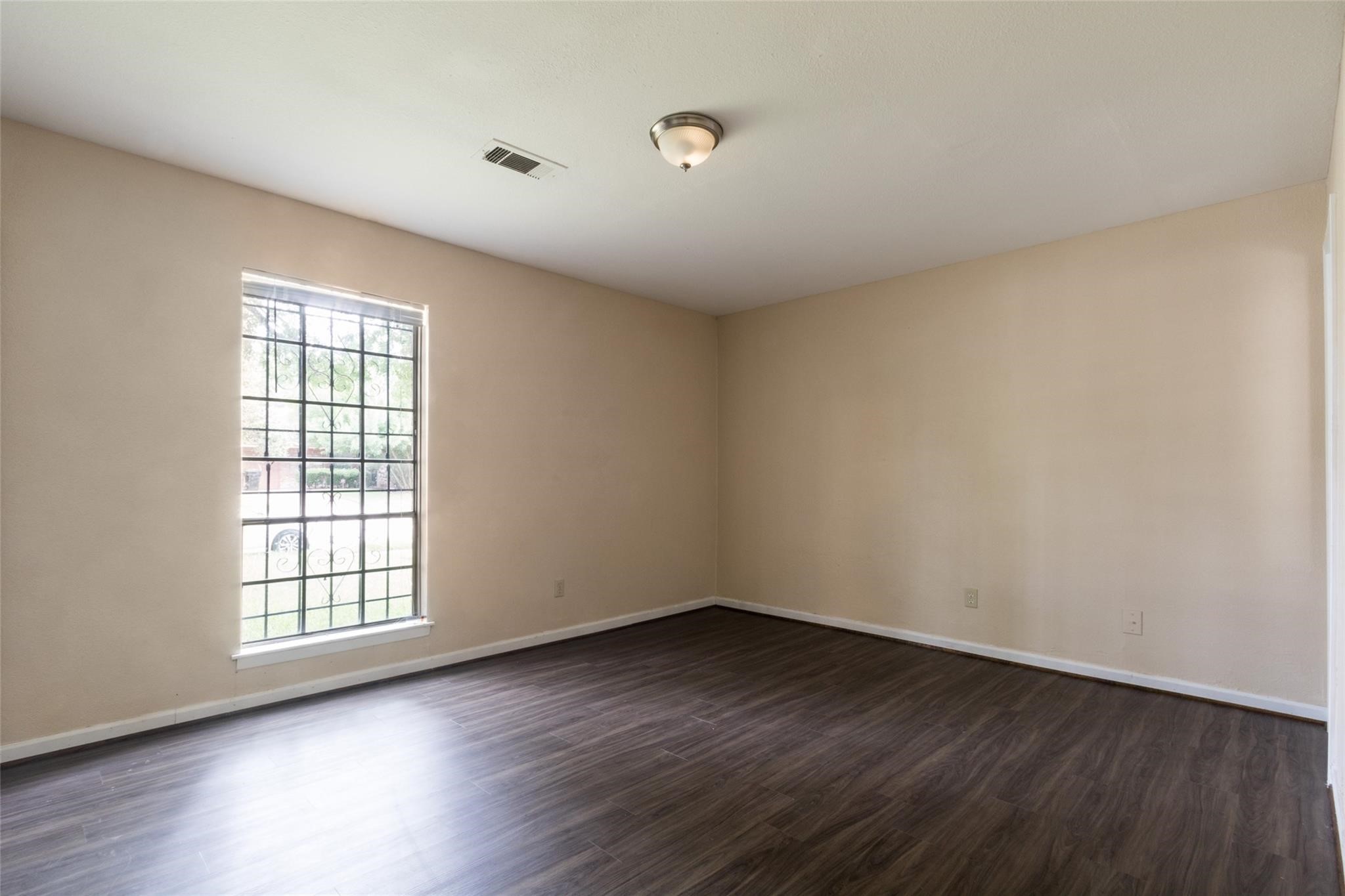 3823 Heatherbrook Drive Houston, TX 77045 - Photo 3 of 11 wooden floor in an empty room with a window