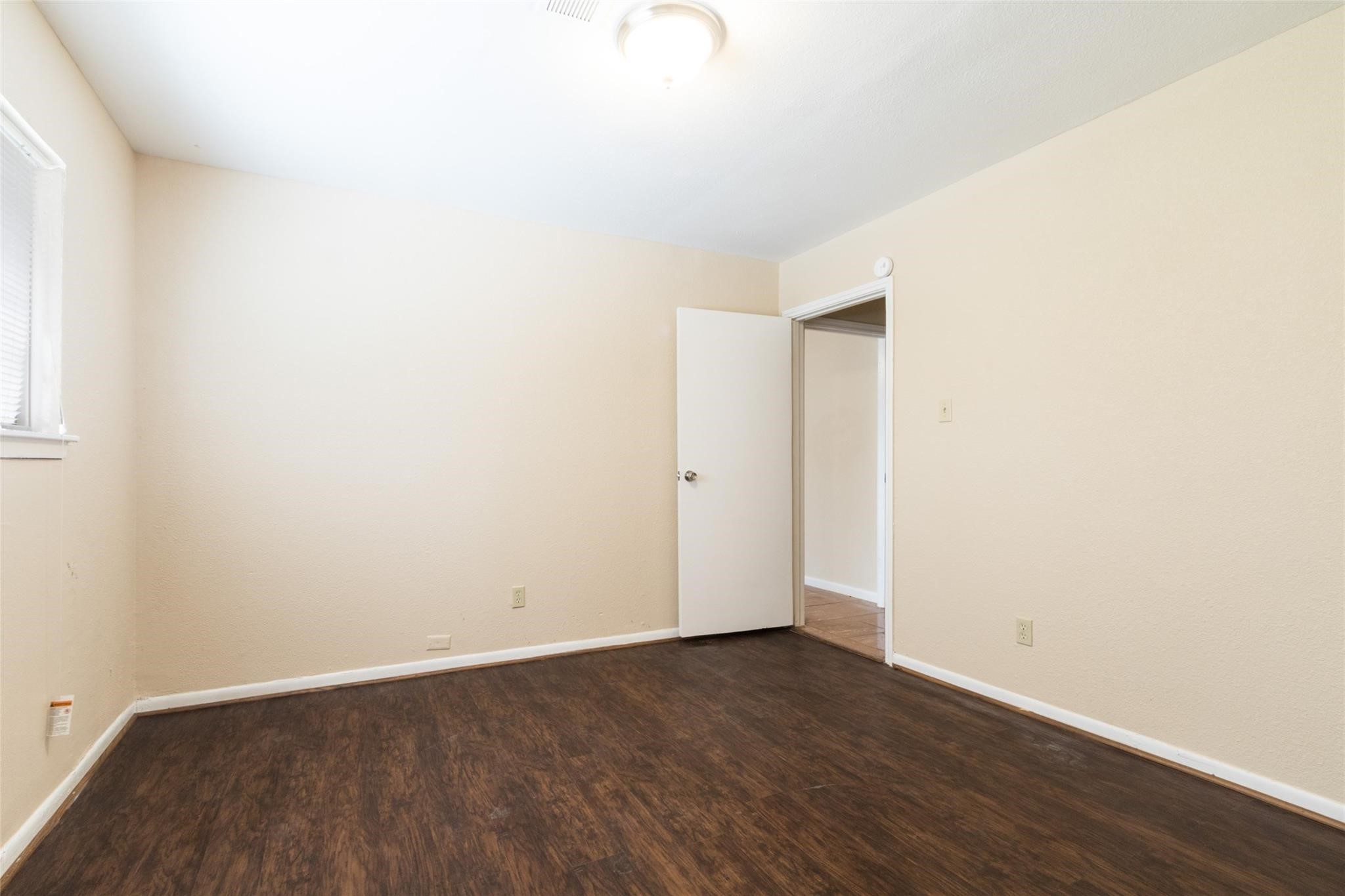 3823 Heatherbrook Drive Houston, TX 77045 - Photo 9 of 11 a view of an empty room with wooden floor