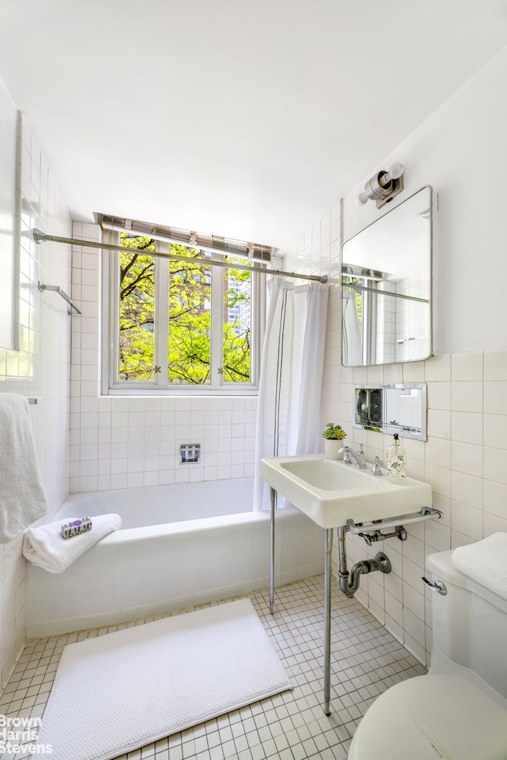 169 East 69th Street, Unit 3C Manhattan, NY 10021 - Photo 5 of 7 a bathroom with a sink a bathtub and a window