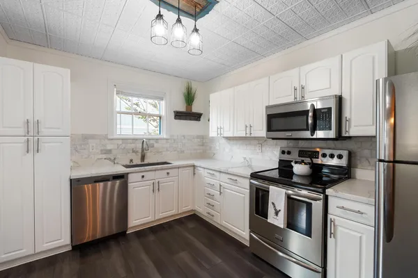 a kitchen with stainless steel appliances a stove sink microwave and cabinets