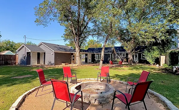a front view of a house with a garden and trees