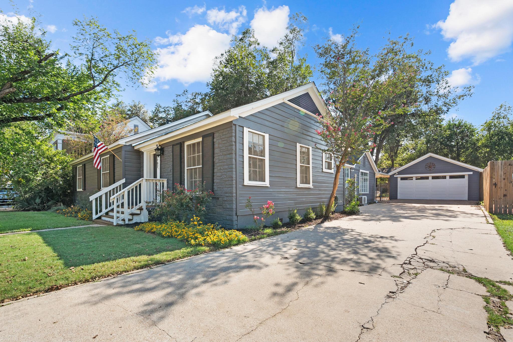 1707 Lexington Street Taylor, TX 76574 - Photo 24 of 29 a front view of a house with a garden and trees