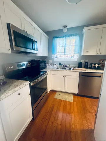 a kitchen with a sink a microwave a stove and cabinets